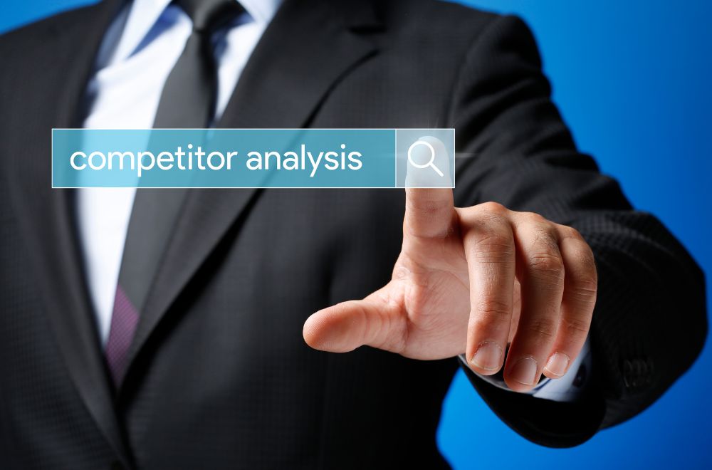 Business Man Pointing To Competitor Analysis Sign