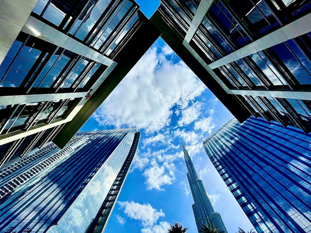 Looking up at Dubai skyscrapers on a sunny day with blue sky