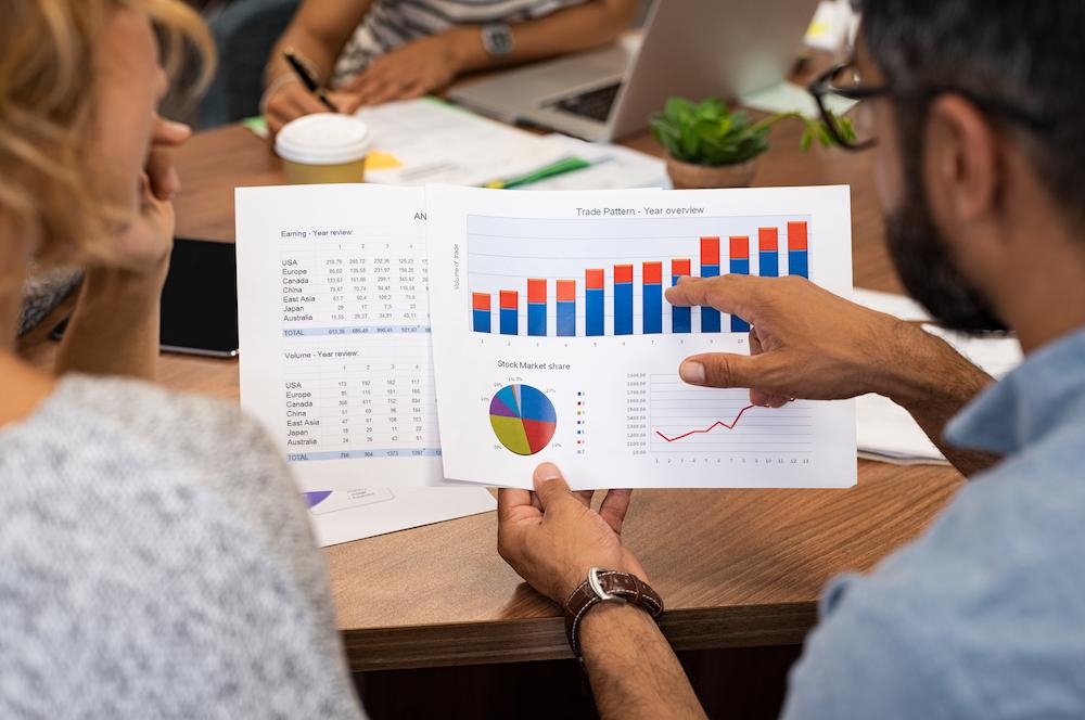 Business owners looking at a printed graph to analyse their current sales strategy