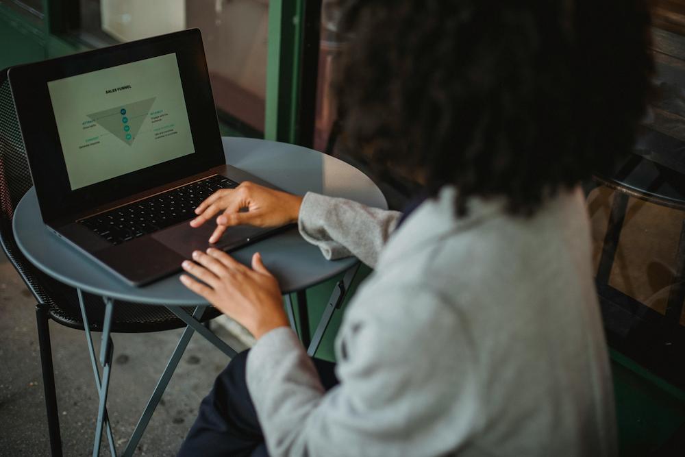 Woman using a laptop looking at the sales funnel to assist her sales strategy going forward