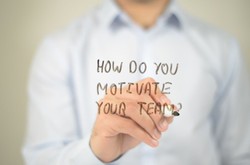 Man Writing On Clearboard &quot;How Do You Motivate Your Team?&quot;