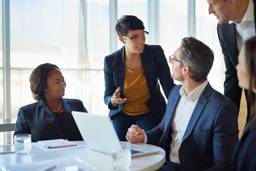 Management consultant discussing business strategy with a professional team.