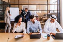 International business team planning a Dubai free zone company setup in a modern office.