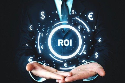 Businessman Holding Sign Reading &quot;ROI&quot;