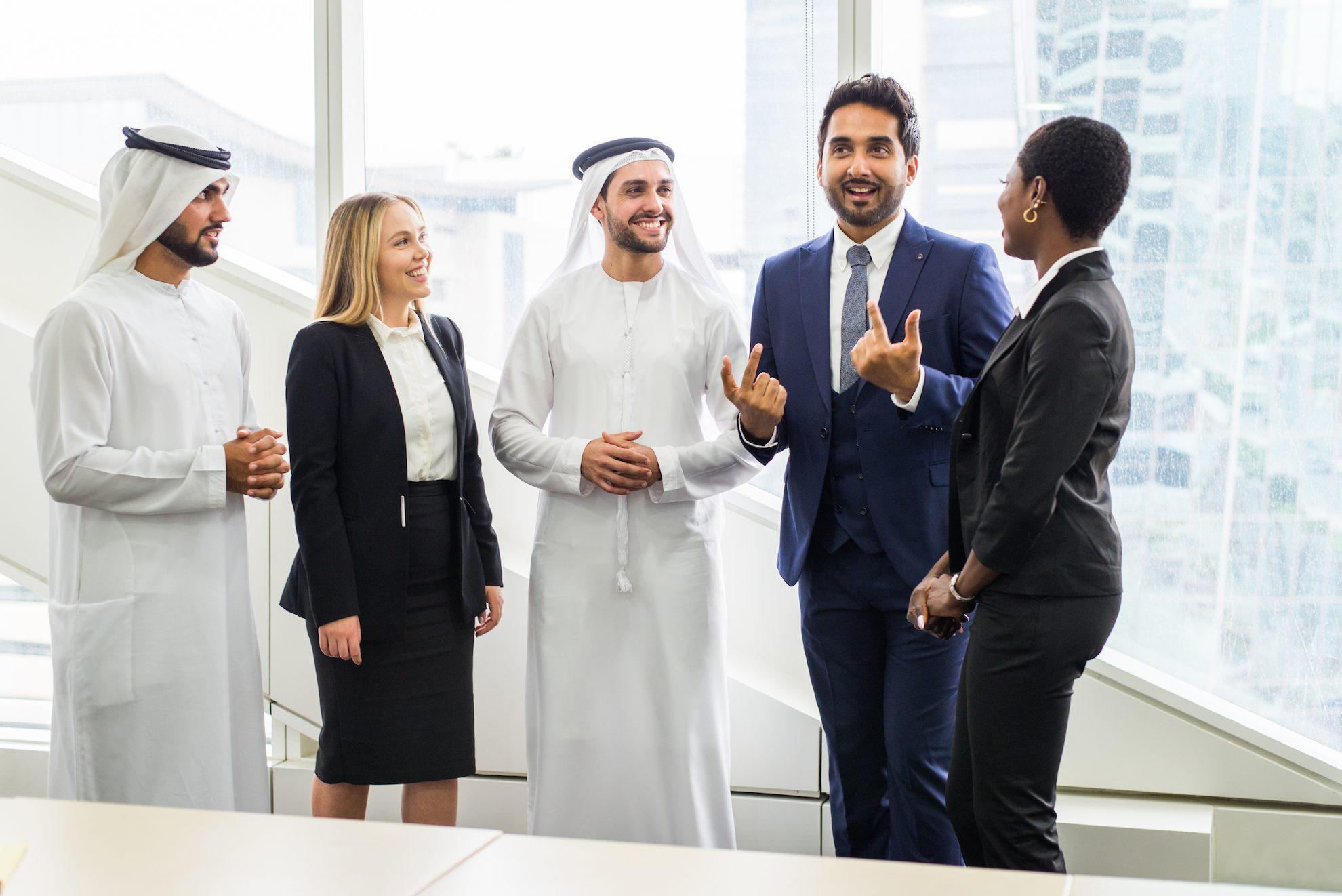 Business professionals discussing Dubai company setup and business activities in a modern office.